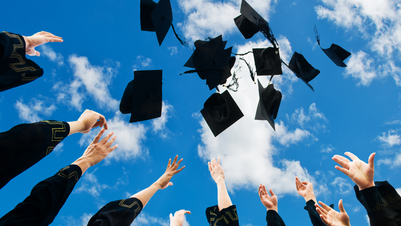 graduation hats being thrown up in the air